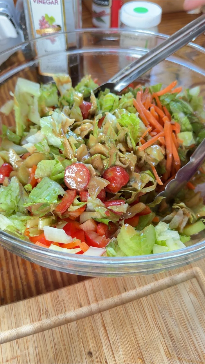 Eric’s Skinny Italian Balsamic Salad with chopped greens, cucumber, tomatoes, carrots, and dressing